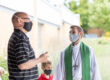 Masked pastor speaking with a masked church member