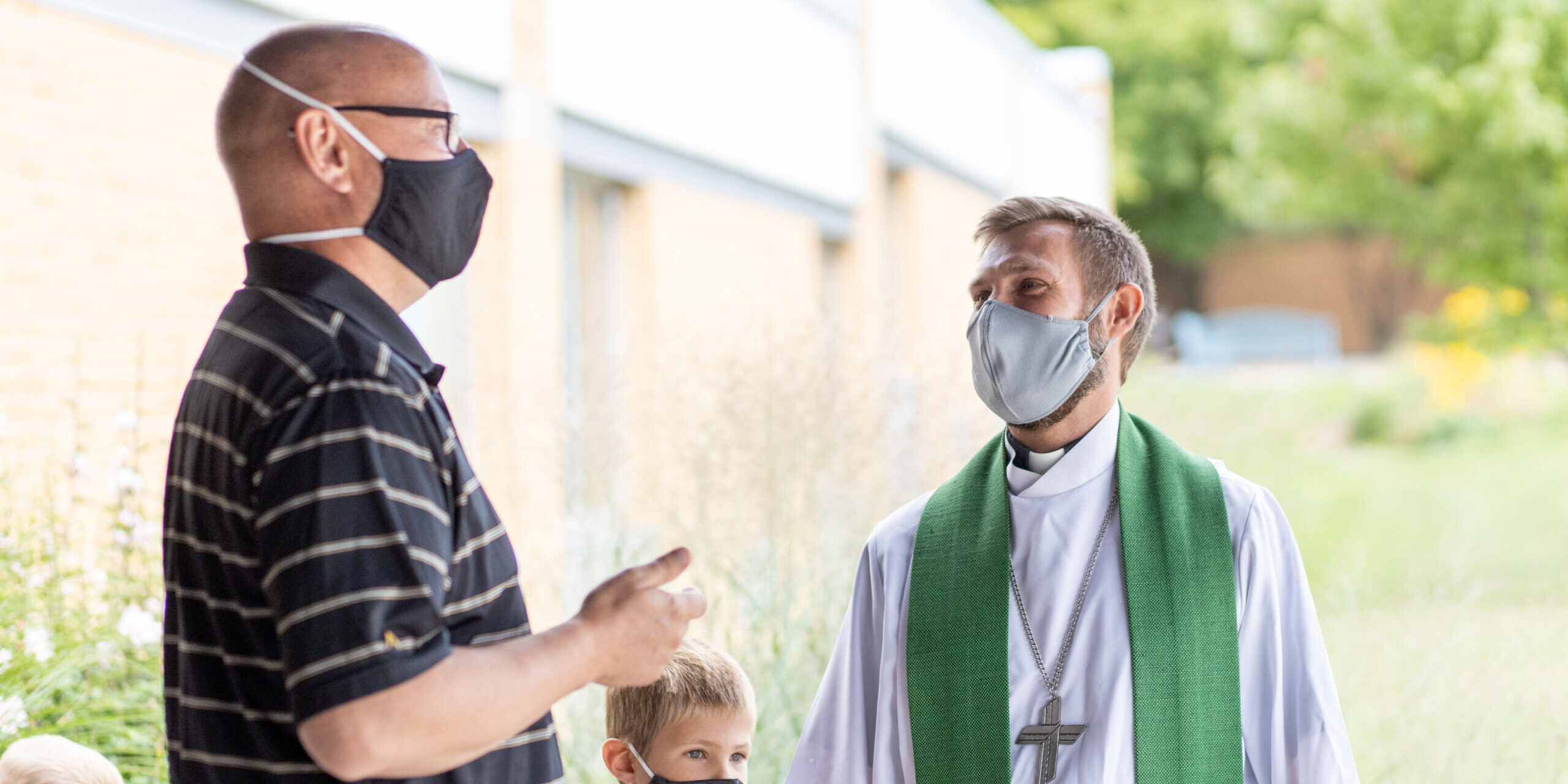 lightstock_741924_full_ann-mask-church-pastor-outside-worship-smaller-file-size Masked pastor speaking with a masked church member