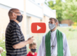 Masked pastor conversing with masked church member
