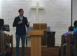 Pastor preaching from the front of a church