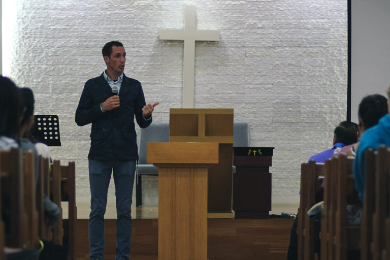 Pastor preaching from the front of a church