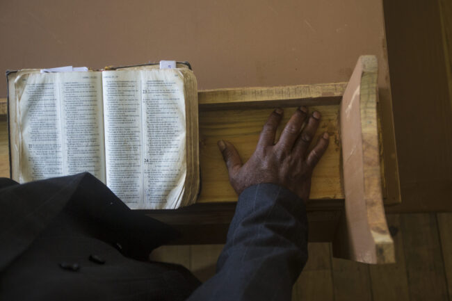 lightstock_63243_full_ann-black-pastor-hands-bible Black pastor at the pulpit